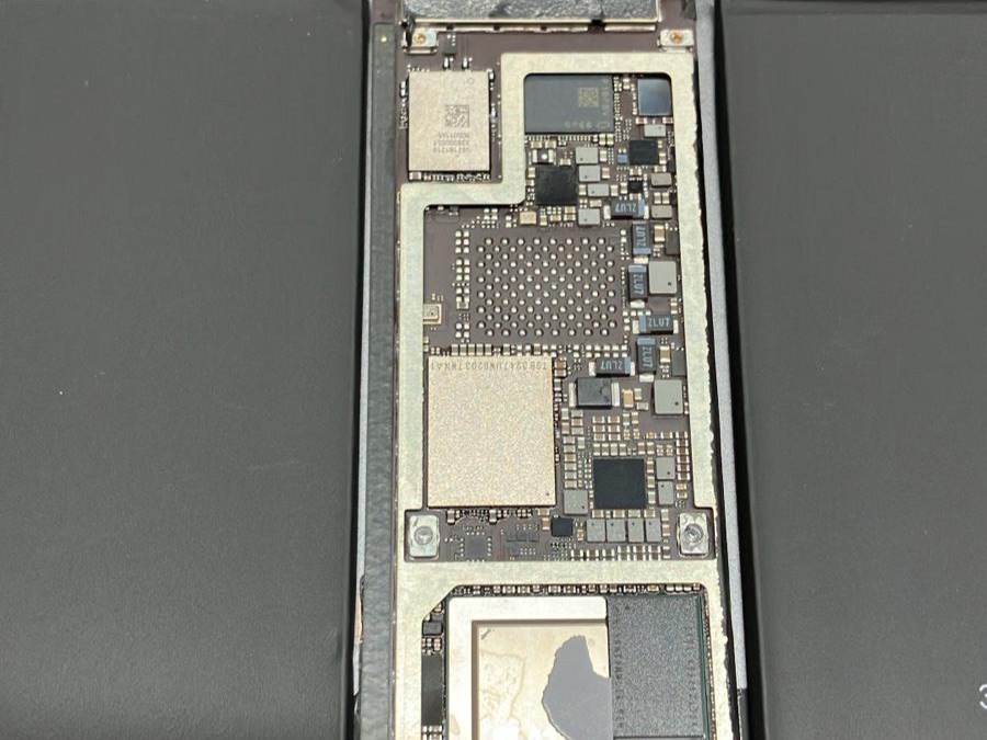 Geopende tablet met zichtbaar moederbord en batterij op de werkbank van Pc Reparatie Twente in Hengelo